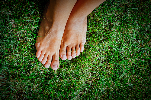 feet standing on healthy lawn