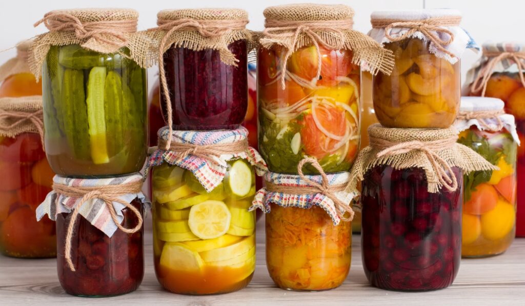 several jars of fruits and veggies that are canned to keep them longer