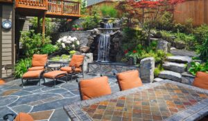 outdoor patio with flowers, rocks and a waterfall